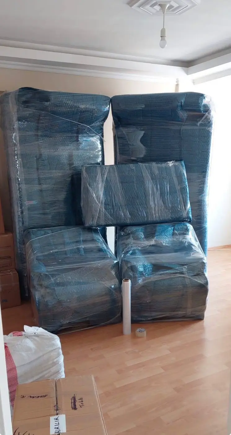 Küçükçekmece nakliyat: mavi koruyucuyla sarılmış koltuk takımı